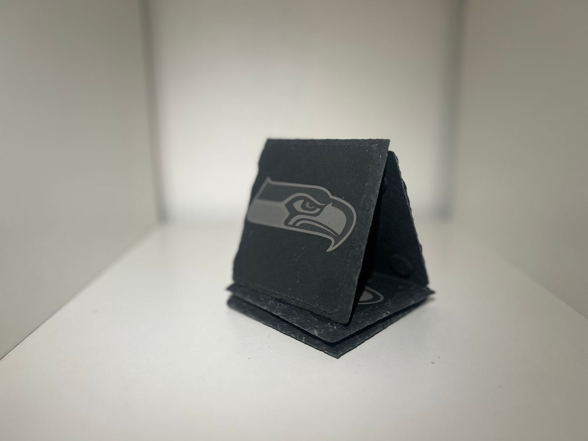 Example of custom laser-engraved square slate coasters on a white background