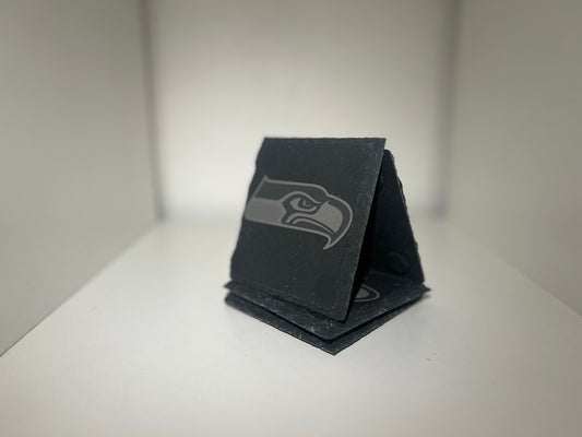Example of custom laser-engraved square slate coasters on a white background